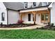 Inviting covered porch featuring natural wood supports and a beautifully landscaped garden at 6110 Harvest Way, Cumming, GA 30028