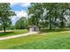 A detached two-car garage is nestled among large trees on a grassy lot at 6110 Harvest Way, Cumming, GA 30028