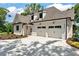Attached two-car garage with white doors, ample parking, and tidy landscaping at 6110 Harvest Way, Cumming, GA 30028