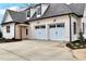 Attached two-car garage showcasing stylish doors and pristine curb appeal at 6110 Harvest Way, Cumming, GA 30028