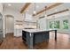 Bright, open kitchen featuring a large island, modern appliances, hardwood floors and wooden beam ceilings at 6110 Harvest Way, Cumming, GA 30028