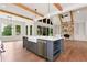 Open concept kitchen with a large island, hardwood floors, stainless steel appliances, and stone fireplace at 6110 Harvest Way, Cumming, GA 30028