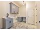 Laundry room featuring gray cabinets, modern sink and countertop with herringbone flooring at 6110 Harvest Way, Cumming, GA 30028