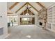 A spacious living room features a stone fireplace, wood beams, vaulted ceiling, and sliding glass doors at 6110 Harvest Way, Cumming, GA 30028