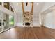 Bright living room with stone fireplace, custom built-ins, hardwood floors, and sliding doors to outdoor space at 6110 Harvest Way, Cumming, GA 30028