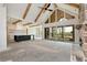 An open-concept living space boasts wood beams, a stone fireplace, and seamless access to an outdoor patio at 6110 Harvest Way, Cumming, GA 30028