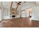 Open living area with vaulted ceiling, stone fireplace, hardwood floors, and access to other rooms at 6110 Harvest Way, Cumming, GA 30028