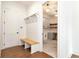 Mudroom featuring built-in bench with hooks, gray cabinets in the laundry room, and wood floors at 6110 Harvest Way, Cumming, GA 30028