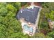 Aerial view showcases a private home nestled amidst lush greenery, featuring a pool, patio, and a long driveway at 2885 Coles Way, Atlanta, GA 30350