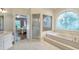 Bright bathroom featuring a soaking tub with large decorative window and walk-in shower at 2885 Coles Way, Atlanta, GA 30350