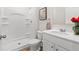 Bathroom with shower, toilet, and sink with white cabinets. Fresh red flowers add a splash of color at 311 Ivy Chase Loop, Dallas, GA 30157