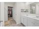 Bright bathroom featuring double sinks, neutral cabinets, and a walk-in closet with ample storage space at 311 Ivy Chase Loop, Dallas, GA 30157