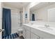 Bathroom featuring double sink vanity, framed mirror, and shower/tub combo with blue shower curtain at 311 Ivy Chase Loop, Dallas, GA 30157