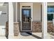 Close-up of the front door with brick accents, a covered porch, and stylish columns at 311 Ivy Chase Loop, Dallas, GA 30157