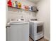 Bright laundry room featuring modern washer and dryer and shelving with supplies at 311 Ivy Chase Loop, Dallas, GA 30157