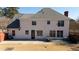 Rear exterior view of the home showcasing neutral siding, windows, concrete patio and a large lawn at 5289 Browning Sw Way, Lilburn, GA 30047