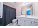 Bright bathroom featuring a white vanity, ample cabinet space, framed mirror, and shower with a dark curtain at 5289 Browning Sw Way, Lilburn, GA 30047