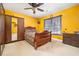 Cozy bedroom with a ceiling fan, wooden sleigh bed, wardrobe, and light yellow walls creating a warm and inviting space at 5289 Browning Sw Way, Lilburn, GA 30047