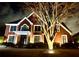 Night view of a two-story brick home with a manicured lawn and decorative front tree at 5289 Browning Sw Way, Lilburn, GA 30047
