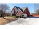 Side exterior of red brick home featuring an attached garage, driveway, and manicured greenery at 5289 Browning Sw Way, Lilburn, GA 30047