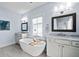 Bright bathroom with a soaking tub, double vanity, and marble countertops at 5930 Brundage Ln, Norcross, GA 30071