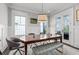 Bright dining room featuring wainscoting, modern lighting, and a wood table with bench seating at 5930 Brundage Ln, Norcross, GA 30071