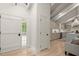 Inviting foyer with wood floors, barn door, and view into the modern kitchen beyond at 6405 Cherry Tree Ln, Atlanta, GA 30328