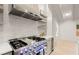 Close-up of a gourmet stainless steel range with a stylish hood and open shelving in a bright, modern kitchen at 6405 Cherry Tree Ln, Atlanta, GA 30328
