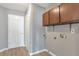 A laundry room with gray walls, wood cabinets, and an area for a washer and dryer hookups at 1321 Stoneleigh Dr, Conyers, GA 30094