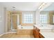 Tiled bathroom with glass shower, separate tub, and double sink vanity at 2848 Stockbridge Way, Dacula, GA 30019