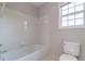 Bright bathroom featuring a standard tub with white tile surround and a toilet at 2848 Stockbridge Way, Dacula, GA 30019