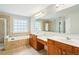 Bathroom featuring double sinks, a large mirror, soaking tub and glass enclosed shower at 2848 Stockbridge Way, Dacula, GA 30019