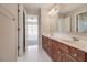 Well-lit bathroom with double vanity and a full-sized mirror leading to a connected bedroom at 2848 Stockbridge Way, Dacula, GA 30019