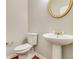 Traditional powder room with pedestal sink, decorative mirror, and wood floors at 2848 Stockbridge Way, Dacula, GA 30019