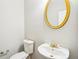 Powder room with modern pedestal sink, gold faucet, and round mirror at 2848 Stockbridge Way, Dacula, GA 30019