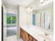 Bathroom featuring double sinks, a large mirror, and a view to another room at 2848 Stockbridge Way, Dacula, GA 30019