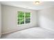 Bedroom with a large window offering natural light and scenic outdoor views of the surrounding trees at 2848 Stockbridge Way, Dacula, GA 30019
