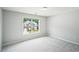 Bedroom with neutral color walls and a large window overlooking the front yard at 2848 Stockbridge Way, Dacula, GA 30019