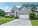Attractive two-story home with a brick facade, a well-kept lawn, and a paved driveway leading to the garage at 2848 Stockbridge Way, Dacula, GA 30019