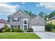 Charming two-story brick home featuring a well-manicured lawn, flowering shrubs, and an attached two-car garage at 2848 Stockbridge Way, Dacula, GA 30019