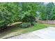 Manicured backyard with mature trees, verdant lawn, and flowerbeds adding natural beauty to the landscape at 2848 Stockbridge Way, Dacula, GA 30019