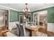 Spacious dining room featuring hardwood floors and stylish light fixture, with entrances to other rooms at 5114 Parkwood Oaks Ln, Mableton, GA 30126