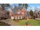 Beautiful two-story red brick home with a manicured lawn and a long driveway leading to a garage at 5114 Parkwood Oaks Ln, Mableton, GA 30126