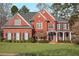 Charming two-story red brick home with a well-manicured lawn and beautiful landscaping at 5114 Parkwood Oaks Ln, Mableton, GA 30126