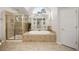 A luxurious bathroom features a jacuzzi tub, a stand-up shower, and neutral tile at 5114 Parkwood Oaks Ln, Mableton, GA 30126