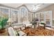 Bright sunroom with natural light, cathedral ceiling, access to outside deck, comfortable seating, and neutral decor at 5114 Parkwood Oaks Ln, Mableton, GA 30126