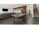 Entertaining basement with rustic wood accents, pool table, and stairway to the upper level at 1830 Marietta Nw Rd, Atlanta, GA 30318
