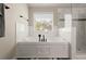 Modern bathroom features a soaking tub with marble tile surround and a glass-enclosed shower at 1830 Marietta Nw Rd, Atlanta, GA 30318