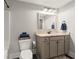 Neutral bathroom features a vanity with granite counters, framed mirror and toilet with blue towels on display at 1830 Marietta Nw Rd, Atlanta, GA 30318