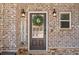 Close-up of the front door with brick surround, wreath, and welcome sign at 1830 Marietta Nw Rd, Atlanta, GA 30318